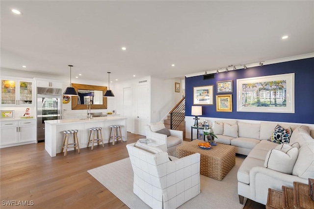 living area with stairway, recessed lighting, and light wood-style floors