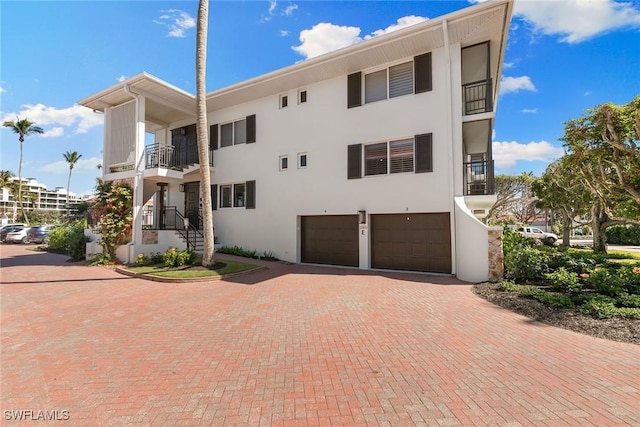 view of property featuring decorative driveway and an attached garage