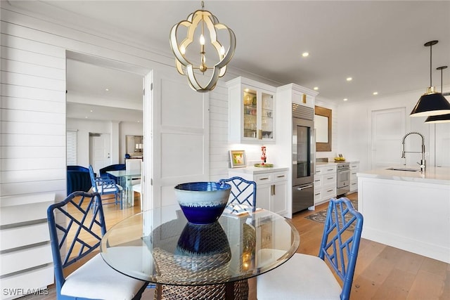 dining area featuring recessed lighting, crown molding, light wood-style flooring, and an inviting chandelier