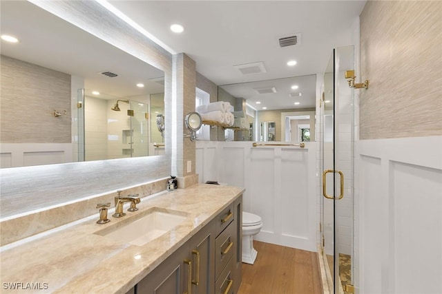 bathroom with a stall shower, visible vents, and wood finished floors