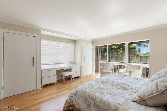 bedroom with ornamental molding, built in study area, and light wood-style flooring