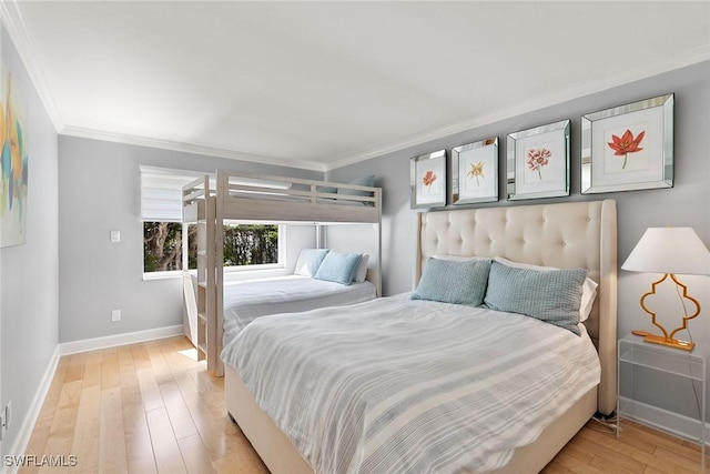 bedroom featuring light wood-style floors, baseboards, and ornamental molding