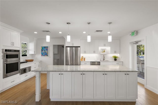 kitchen with white cabinetry, visible vents, stainless steel appliances, and wood finished floors