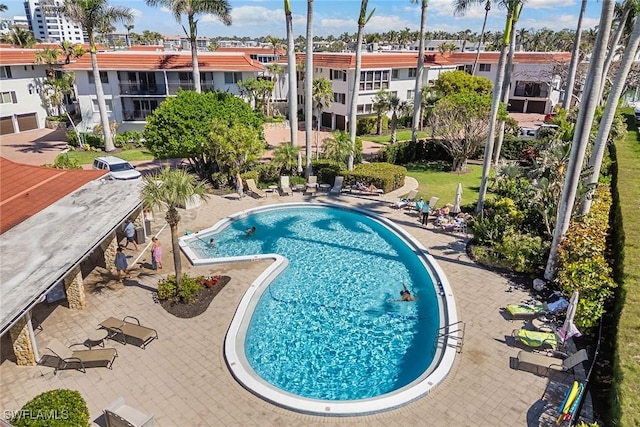 community pool with a patio area and a residential view