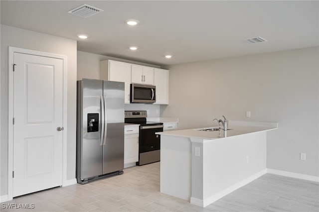 kitchen with appliances with stainless steel finishes, a sink, visible vents, and white cabinetry