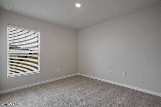 spare room featuring a healthy amount of sunlight, baseboards, carpet flooring, and recessed lighting