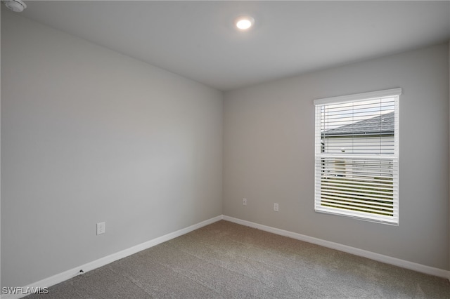 carpeted empty room with a healthy amount of sunlight and baseboards