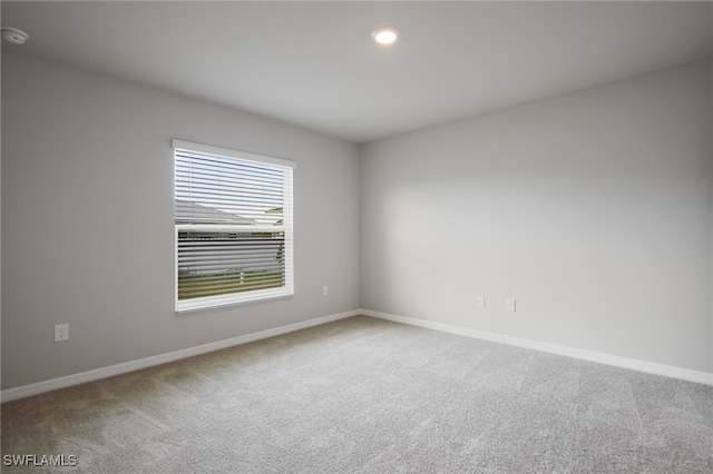 spare room featuring recessed lighting, carpet, and baseboards