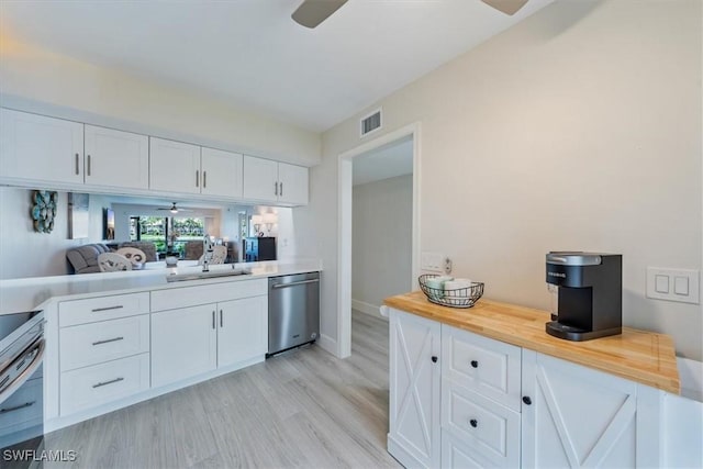 bar featuring light wood finished floors, visible vents, a ceiling fan, appliances with stainless steel finishes, and a sink