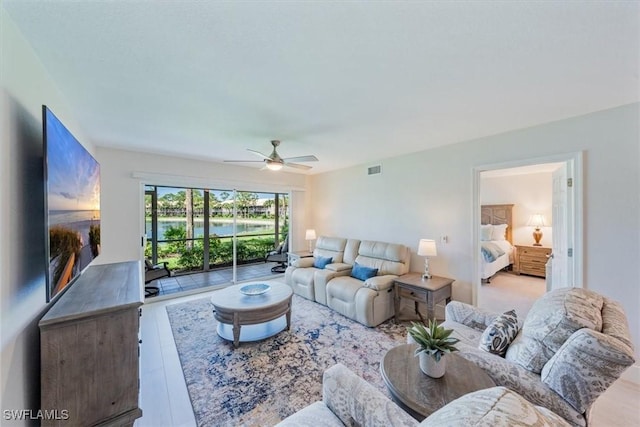 living room with ceiling fan, wood finished floors, and visible vents
