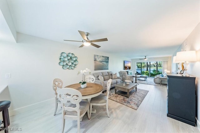 dining space featuring light wood-type flooring, baseboards, and a ceiling fan