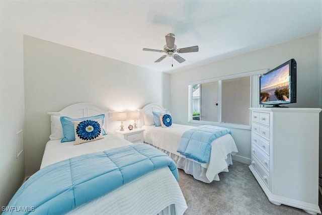 bedroom with light colored carpet, ceiling fan, and baseboards