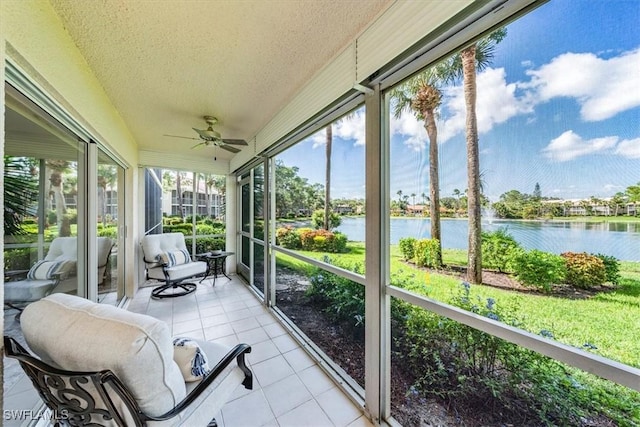 sunroom / solarium with a water view and a ceiling fan