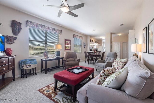 carpeted living area with visible vents, baseboards, and ceiling fan