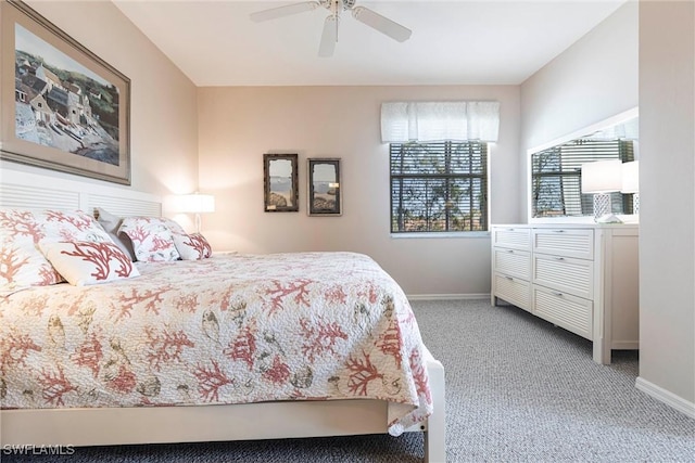 bedroom featuring light colored carpet, baseboards, and ceiling fan