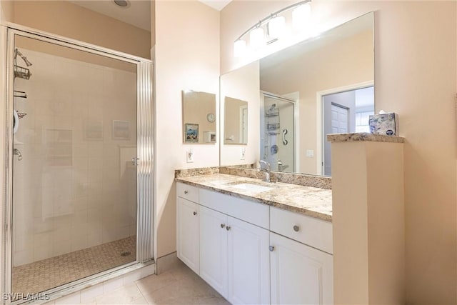 bathroom featuring tile patterned floors, a stall shower, and vanity