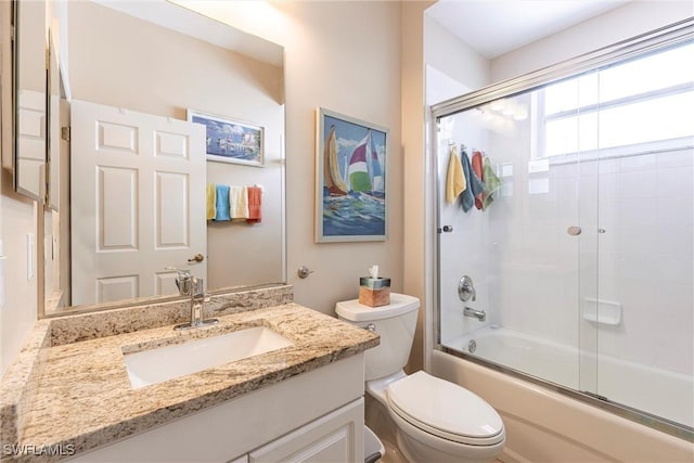 bathroom with shower / bath combination with glass door, toilet, and vanity