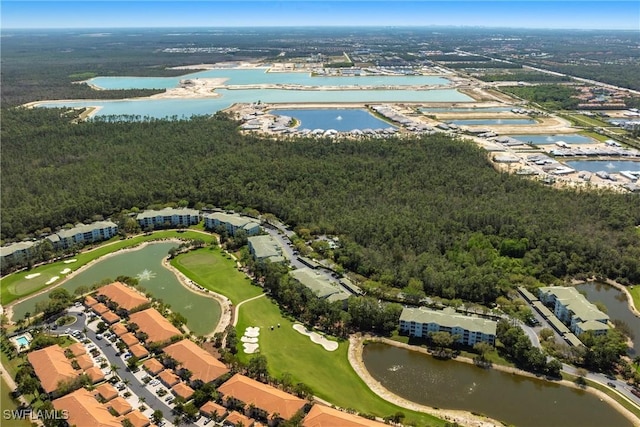 birds eye view of property with a water view and a wooded view