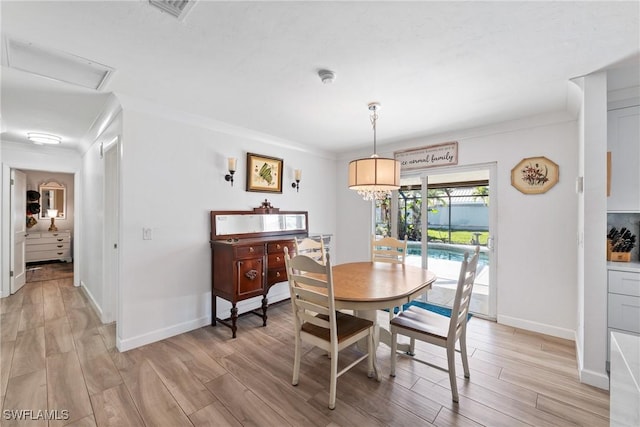 dining area with visible vents, light wood-style floors, and ornamental molding