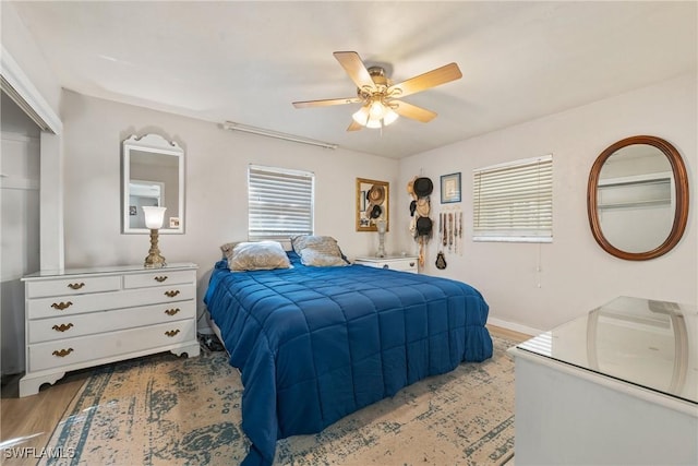 bedroom with baseboards, ceiling fan, and wood finished floors