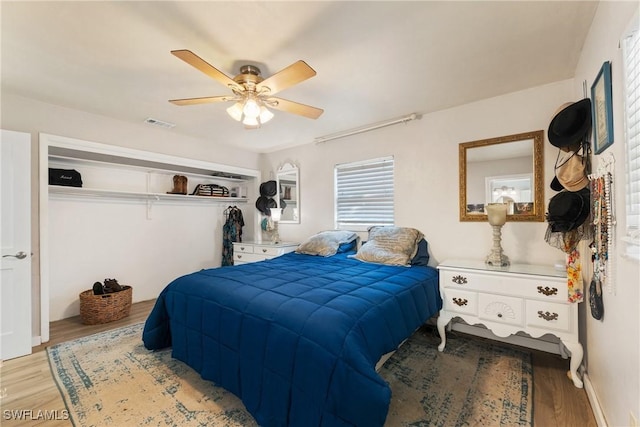 bedroom featuring visible vents, wood finished floors, and a ceiling fan