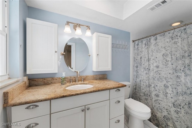 bathroom featuring vanity, a shower with shower curtain, toilet, and visible vents