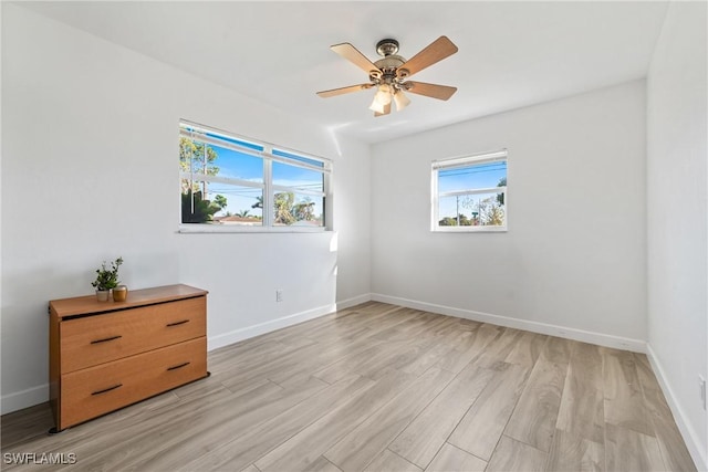 empty room with light wood-style flooring, baseboards, and ceiling fan