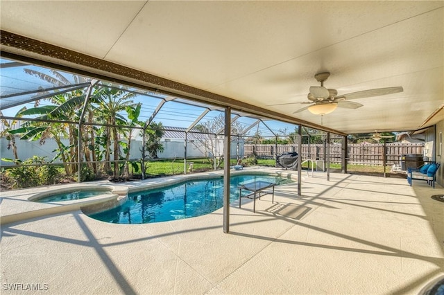 view of swimming pool featuring a patio, a fenced backyard, a pool with connected hot tub, ceiling fan, and a lanai