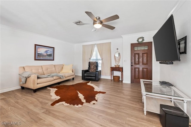 living area featuring visible vents, crown molding, baseboards, ceiling fan, and light wood-style flooring