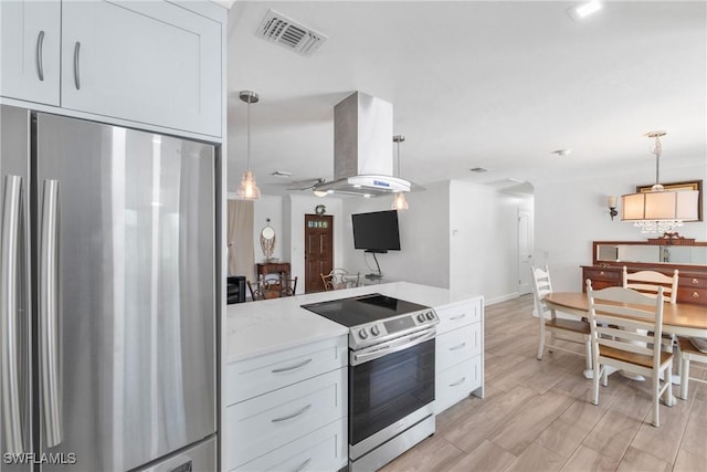 kitchen with visible vents, appliances with stainless steel finishes, light wood-style floors, island range hood, and hanging light fixtures