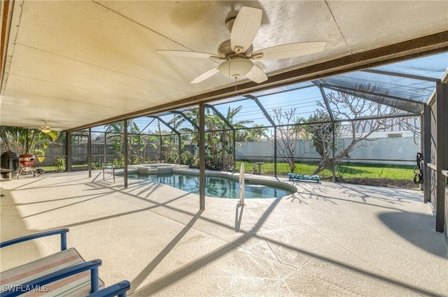 view of swimming pool with a fenced backyard, glass enclosure, a patio, and ceiling fan