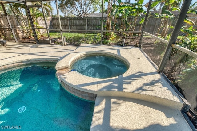 view of pool with a lanai, a fenced backyard, an in ground hot tub, and a patio