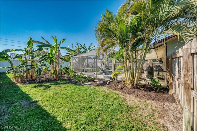 view of yard featuring glass enclosure and a patio