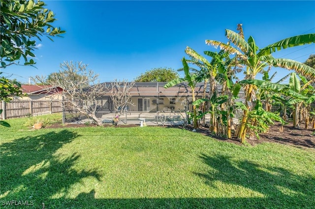 view of yard featuring glass enclosure, a fenced in pool, and fence