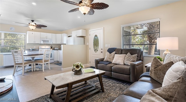 living area with light tile patterned floors and a ceiling fan