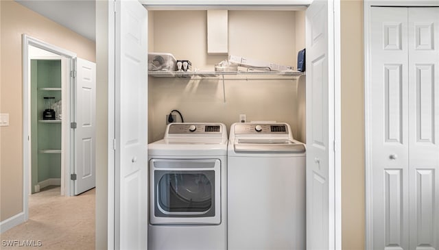 washroom with laundry area, baseboards, and separate washer and dryer