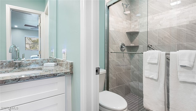 full bathroom with ceiling fan, a stall shower, vanity, and toilet