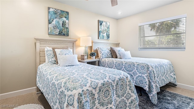 bedroom featuring tile patterned floors, a ceiling fan, and baseboards