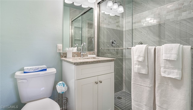 full bathroom featuring toilet, a shower stall, and vanity