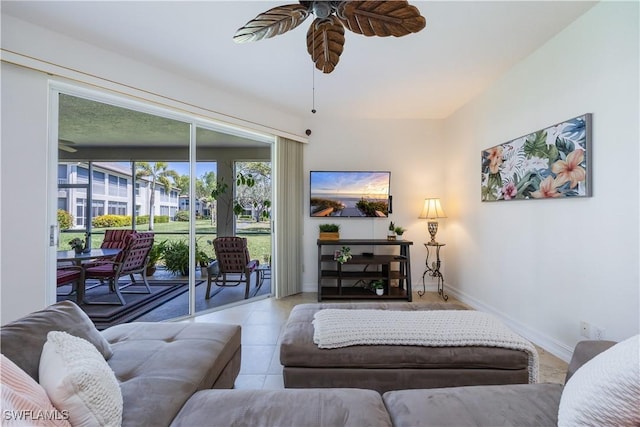 living area featuring baseboards, ceiling fan, and tile patterned flooring