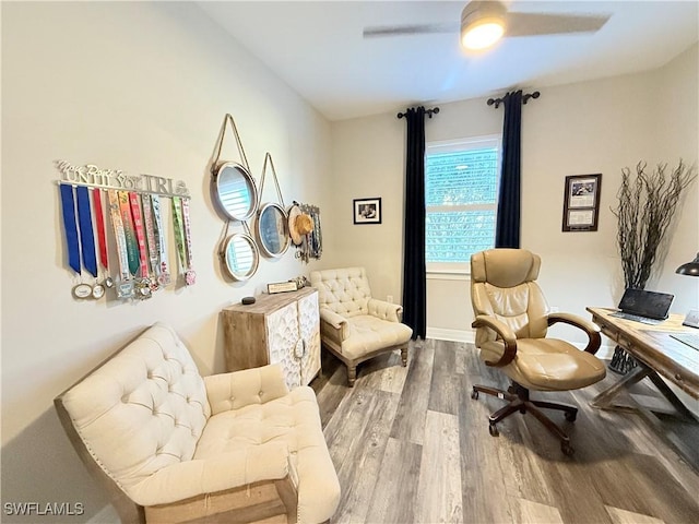 sitting room featuring ceiling fan, wood finished floors, and baseboards