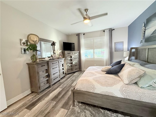 bedroom with a ceiling fan, baseboards, and light wood finished floors