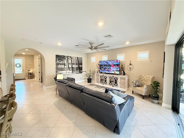 living area featuring arched walkways, visible vents, recessed lighting, and light tile patterned floors