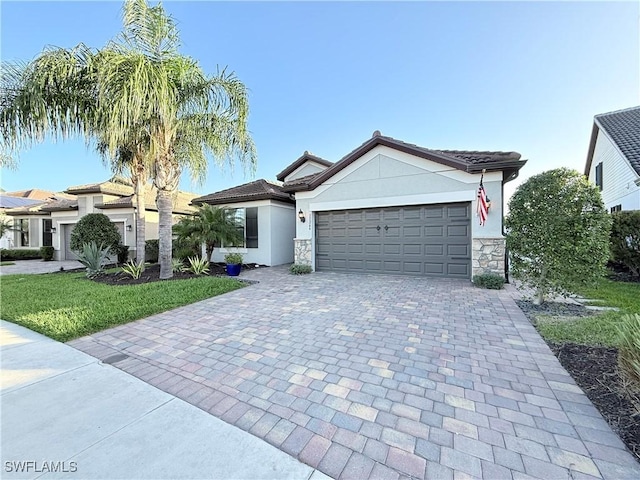 view of front of house featuring a garage, stone siding, decorative driveway, and stucco siding