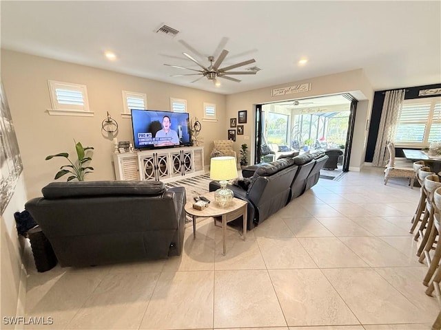 living area featuring a healthy amount of sunlight, light tile patterned floors, ceiling fan, and visible vents