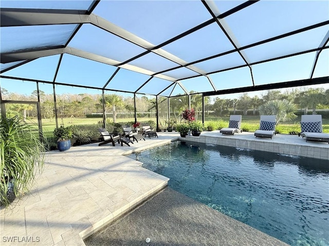 outdoor pool featuring glass enclosure and a patio