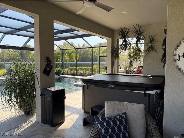 view of patio featuring ceiling fan, glass enclosure, an outdoor pool, and a hot tub