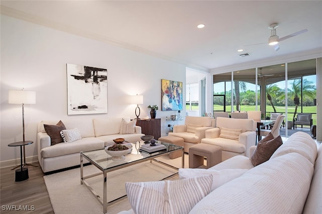 living room featuring expansive windows, a healthy amount of sunlight, wood finished floors, and visible vents