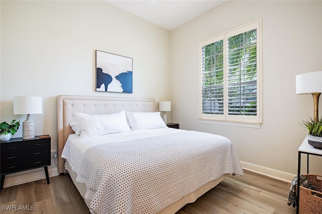 bedroom featuring wood finished floors and baseboards