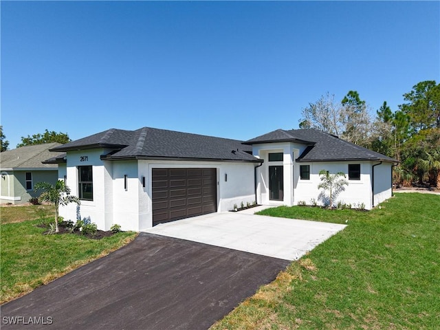 prairie-style home with a garage, concrete driveway, roof with shingles, and a front lawn